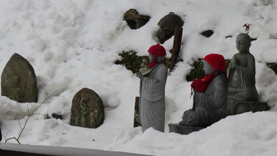 雪に映える赤い頭巾をかぶったお地蔵さまも